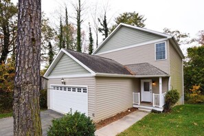 A two-story house with a garage, a front porch, and a small front yard.