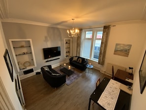 Relax in this stylish living room with a flat-screen TV, comfortable sofa, and dining area.