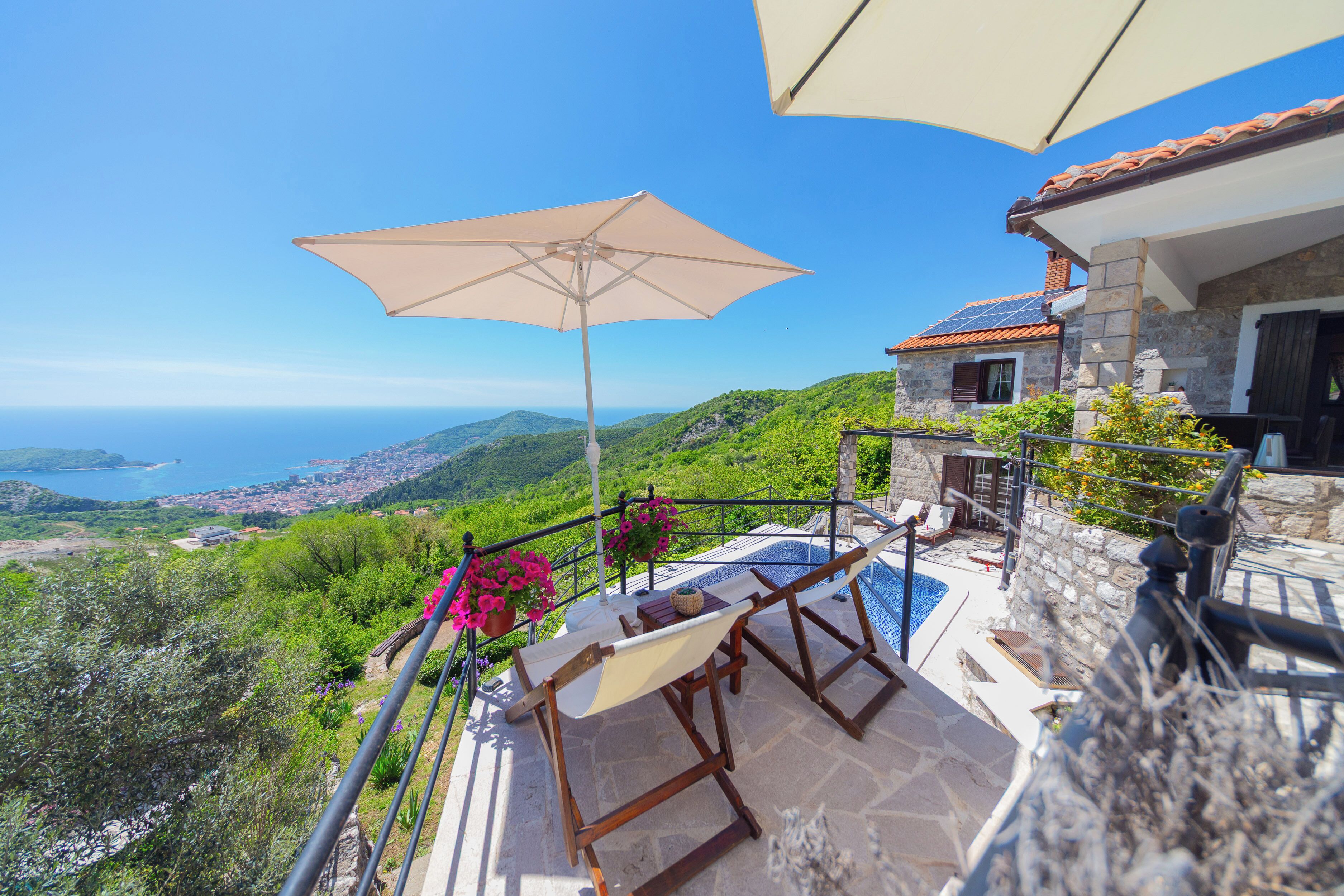 Un balcon avec vue sur la mer, une piscine et une table avec une chaise.
