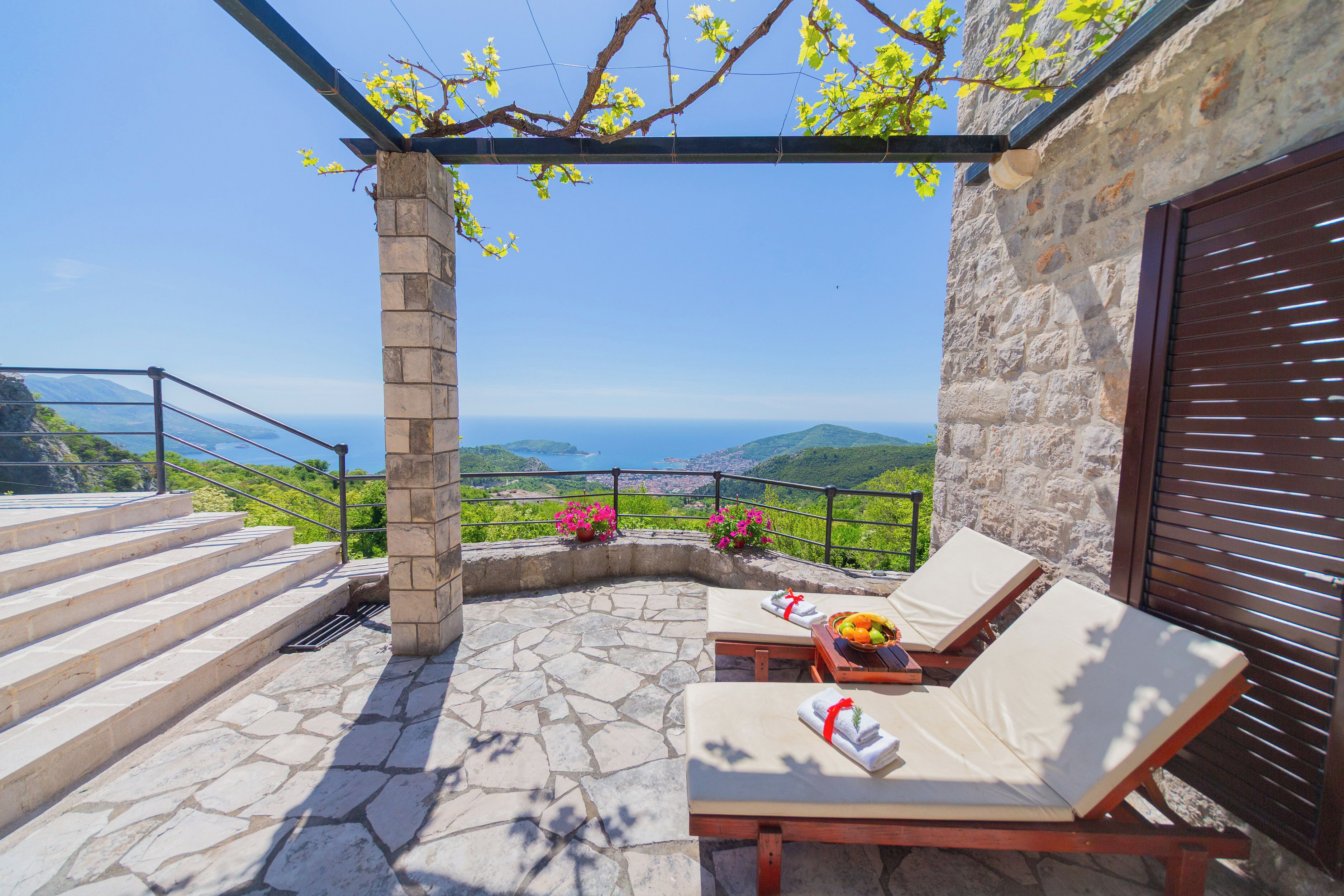 Une terrasse en pierre avec des marches menant à une autre terrasse offrant une vue panoramique.