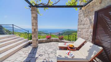 Une terrasse en pierre avec des marches menant à une autre terrasse offrant une vue panoramique.