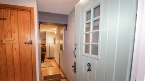 A hallway with a wooden door labeled "Laundry" and a light blue door with a window and the number "2" on it.