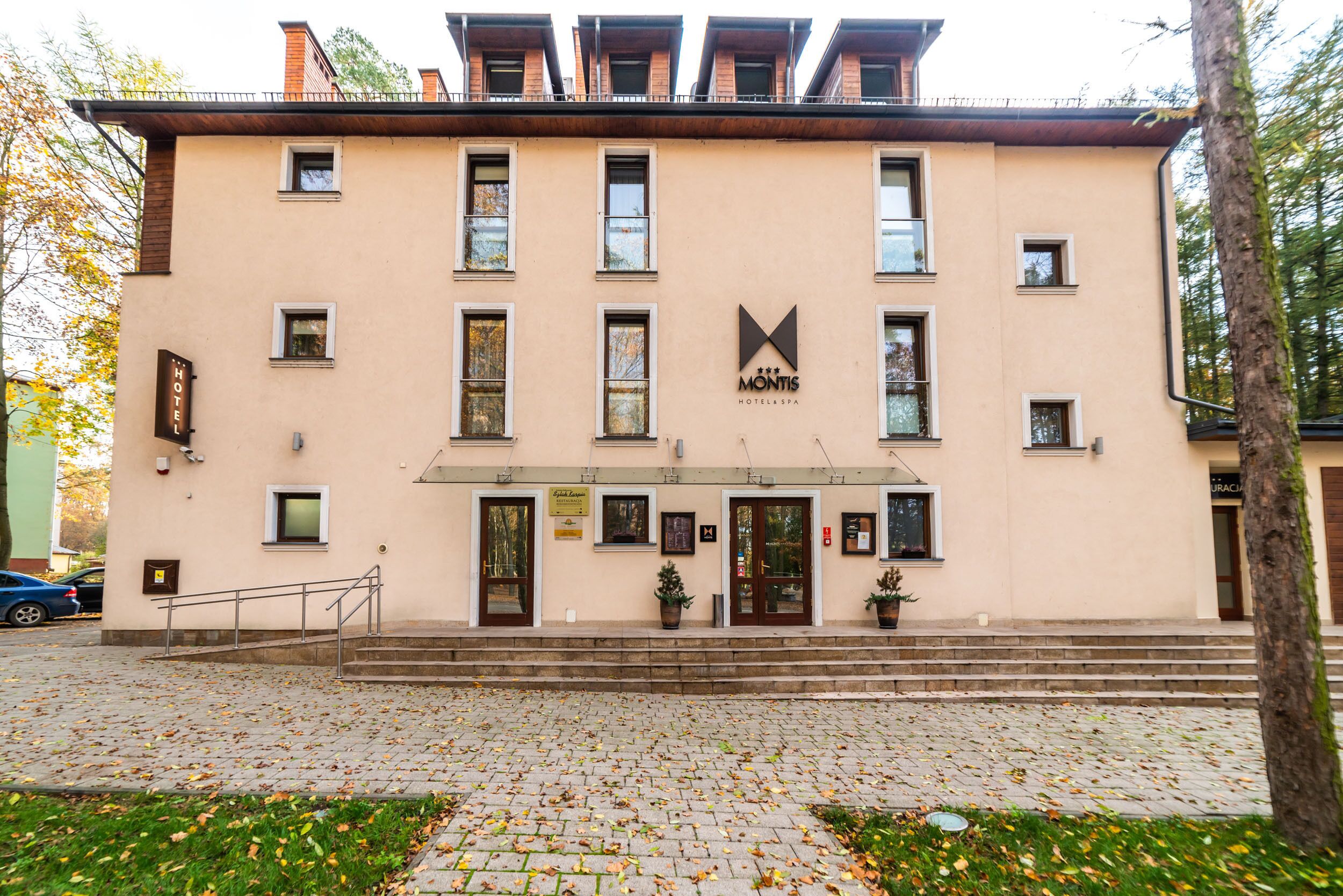 Un hotel con facciata beige, diverse finestre e una segnaletica che indica che si tratta di un albergo.