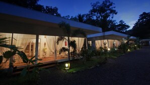 A modern, well-lit building with large glass windows and a covered outdoor area. - Casa Blanca Villas Ojochal (Ciudad Cortés)