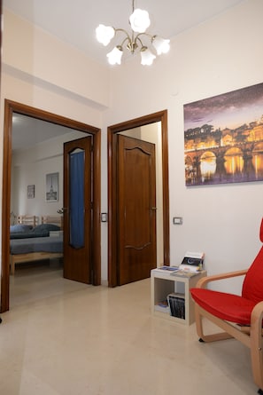 Une pièce comprenant un lit, une chaise, une bibliothèque et un tableau accroché au mur.