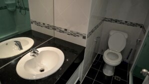 Un baño con dos lavabos, un inodoro y una zona de ducha.