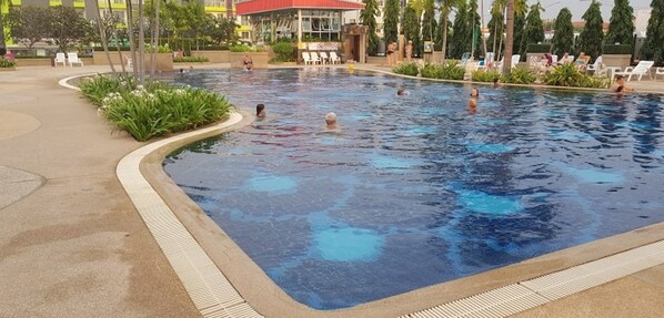 Relax by the pool surrounded by lush greenery and modern architecture.