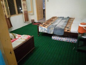 Cozy retreat with a single bed, patterned bedspread, and a compact table.