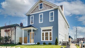 A two-story house with a porch, a chimney, and a well-maintained lawn.