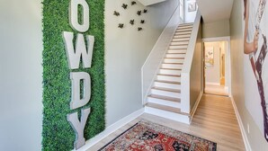 A staircase with a wooden finish and a red patterned rug at the base.