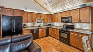 A kitchen with wooden cabinets, a refrigerator, a microwave, a stove, and a dishwasher. - Clean & Cozy. Walk to 3 beaches. Dog friendly. (Tahoe City)