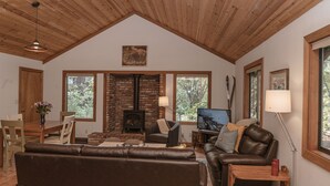 A cozy living room with a fireplace, leather sofa, and a TV. - Clean & Cozy. Walk to 3 beaches. Dog friendly. (Tahoe City)
