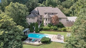 A large, multi-story house with a swimming pool, surrounded by dense trees and a well-maintained lawn. - Blackwater Castle w/ Private Pool, Arcade, Hot Tub (Wirtz)