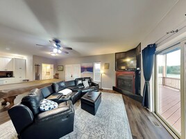 A modern living room with a sectional sofa, a fireplace, and a view of a deck.