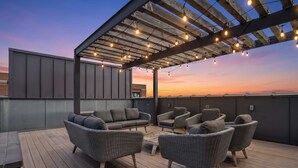 An outdoor seating area with wicker furniture and string lights. - 2 Luxe Nashville Homes | Near to Broadway (Nashville)