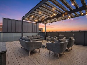 An outdoor seating area with wicker furniture and string lights. - 2 Luxe Nashville Homes | Near to Broadway (Nashville)