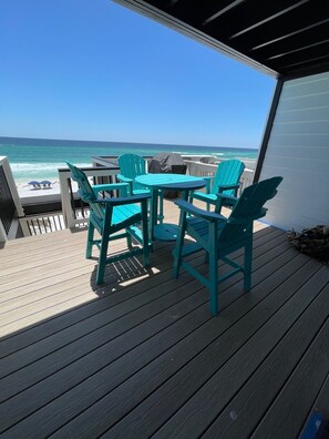 Une terrasse avec une table et des chaises donnant sur l’océan.