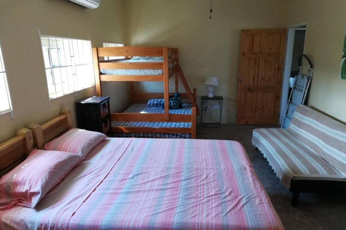A room with a bunk bed, a single bed, and a wooden wardrobe.