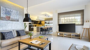 A modern living room with a sofa, coffee table, and a TV. - Villa Sunny Day with Pool (Labin)