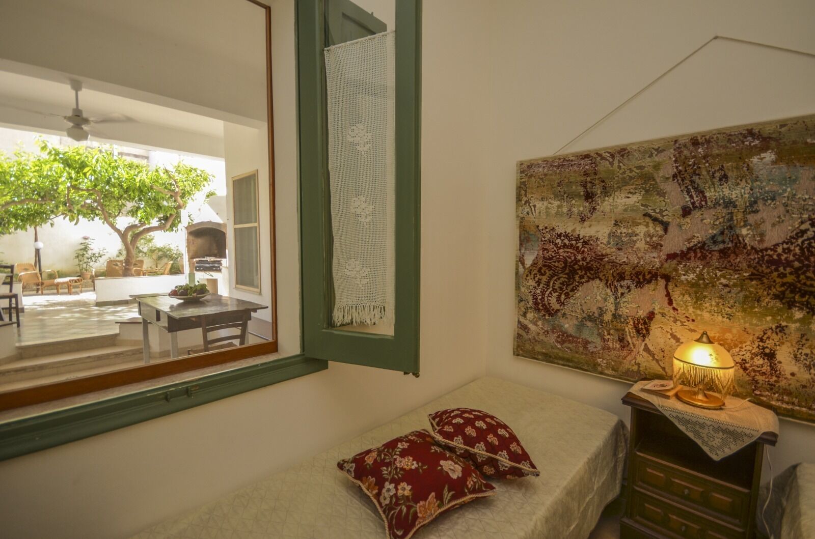 Ein gemütliches Zimmer mit einem Bett, einem Schreibtisch und einem Fenster mit Blick auf einen Garten.