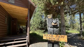 Relax on the porch of Bear Paw Lodge, surrounded by lush greenery.