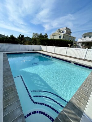 A rectangular swimming pool with clear blue water, surrounded by a white fence and a tiled deck. - Renovated Home with Heated Pool 3 Bed/2 Bath - Sleeps 6 (Avalon)