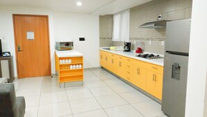 A modern kitchen with a refrigerator, microwave, and coffee maker on the counter. - Villas Analco Apartments (Puebla)