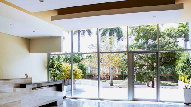A spacious lobby with a reception desk, large windows, and a view of the outdoors. - Apartamento Vacacional en Barranquilla (Barranquilla)