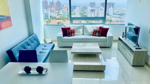 A modern living room with a sofa, coffee table, and TV stand. - Apartamento Vacacional en Barranquilla (Barranquilla)