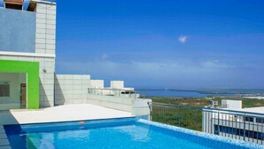 A rooftop pool with a clear view of the ocean and distant land. - Apartamento Vacacional en Barranquilla (Barranquilla)