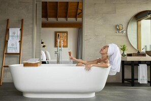 A modern bathroom with a freestanding bathtub, a wooden ladder, a towel rack, and a mirror. - Emerald Faarufushi Resort & Spa (Faarufushi)