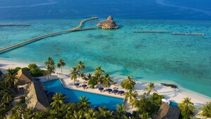 An aerial view of a resort with a swimming pool, palm trees, and a beach. - Emerald Faarufushi Resort & Spa (Faarufushi)