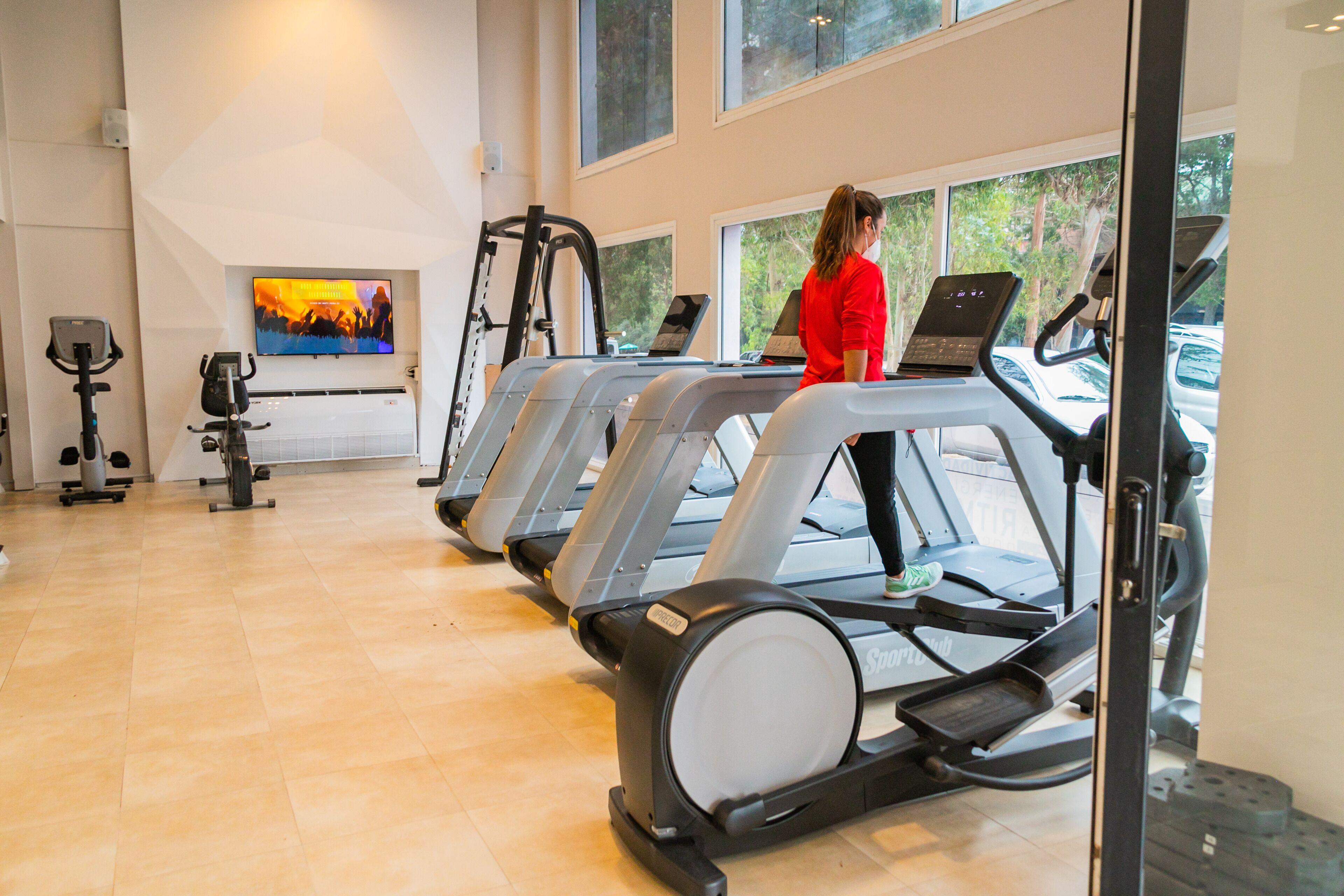 A gym with treadmills, a stationary bike, and a rowing machine.