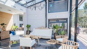 A modern interior with a white sofa, wooden chairs, and a glass ceiling. - Garden Suites Pinamar (Pinamar)