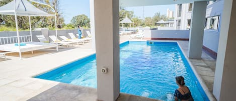 Una piscina al aire libre, sombrillas