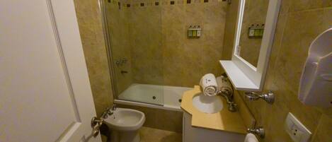 Une petite salle de bain comprenant des toilettes, un bidet et une baignoire.