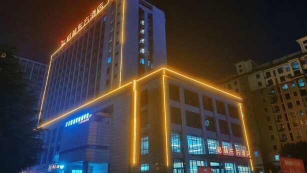 Un edificio de hotel de varios pisos con señalización iluminada y una entrada destacada.