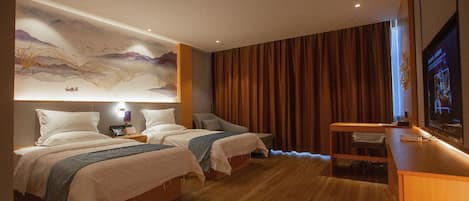 A hotel room with two beds, a desk, a television, and a mural on the wall.