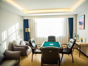 A hotel room with a pool table, leather chairs, a sofa, and a large window with curtains. - Greentree Eastern Tongling Yian District Government Hotel (Tongling)