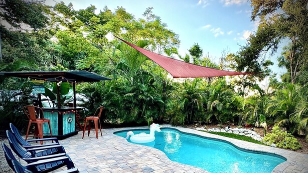 A swimming pool with lounge chairs and a shaded area. - Bungalow w/ Heated Pool by Downtown & Beaches (Sarasota)