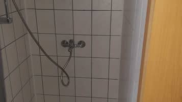 Suihkussa on käsisuihkupää ja seinään asennettu hana.
