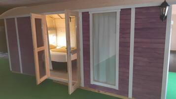 A room with a bed, a window, and a door.