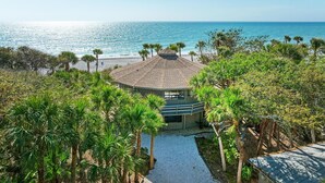 A beachfront property with a circular building, palm trees, and a clear view of the ocean. - The Turtle House-Miles and Miles of Private Beach-Sunset Views! (Englewood)