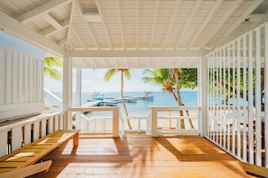 Una terraza de madera con vista al mar y un muelle.