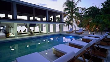 Una piscina al aire libre, tumbonas