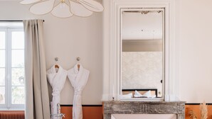 Une salle de bain moderne avec une baignoire sur pieds, un grand miroir et une cheminée.