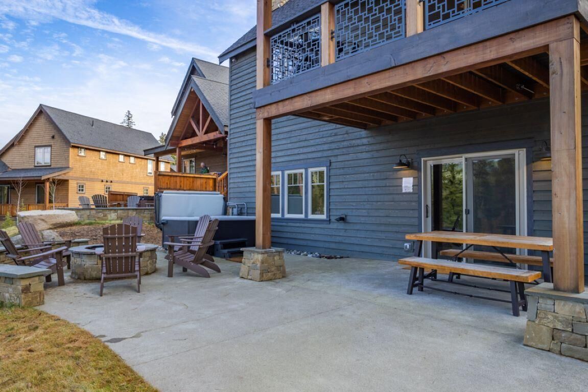 A building with a covered patio area featuring outdoor seating and a barbecue grill.
