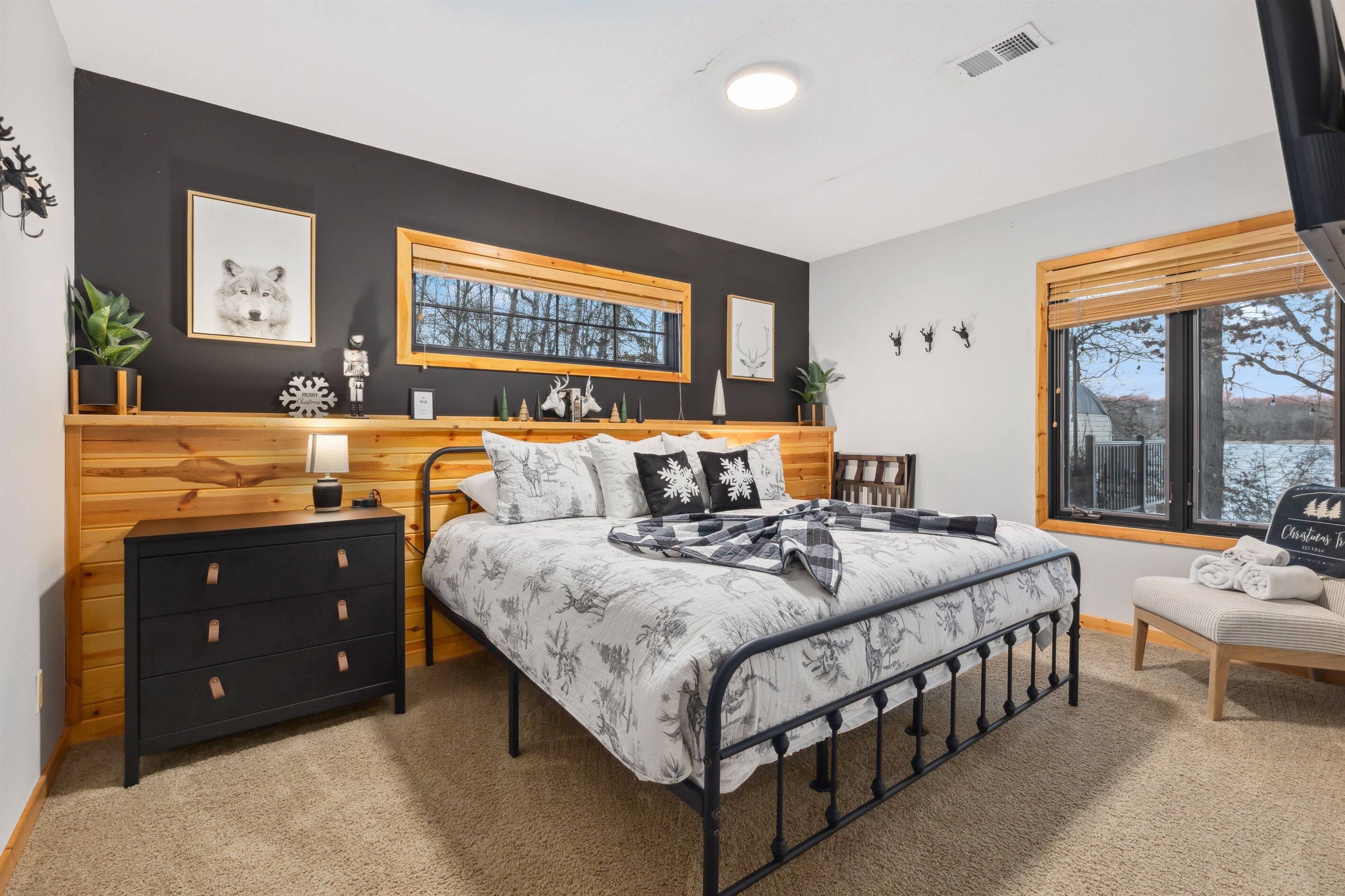 A bedroom with a bed, bedside tables, a dresser, a window, and wall decorations.