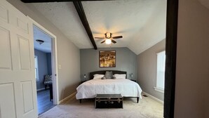 A bedroom with a bed, a ceiling fan, and a suitcase on the floor. - **Stylish Pet Friendly 3 Bedroom House** (Cleveland)