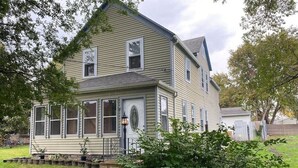 A two-story house with a front porch, a small garden, and a wooden fence. - **Stylish Pet Friendly 3 Bedroom House** (Cleveland)